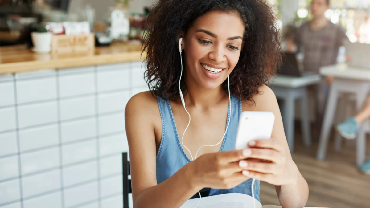 Woman smiling at phone in cafe setting